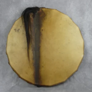 Tambour chamanique artisanal vu de face, en peau de cheval glabrée couleur miel avec une bande sombre centrale, surface mêlant zones à poils ras et lisses, une crinière noire visible, monté sur un cadre en bois de peuplier.